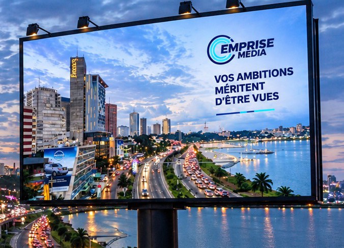 Un panneau Emprise Média face à la baie d’Abidjan au crépuscule
